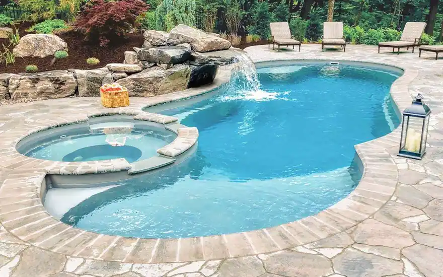 Freeform pool and spa with a rock waterfall