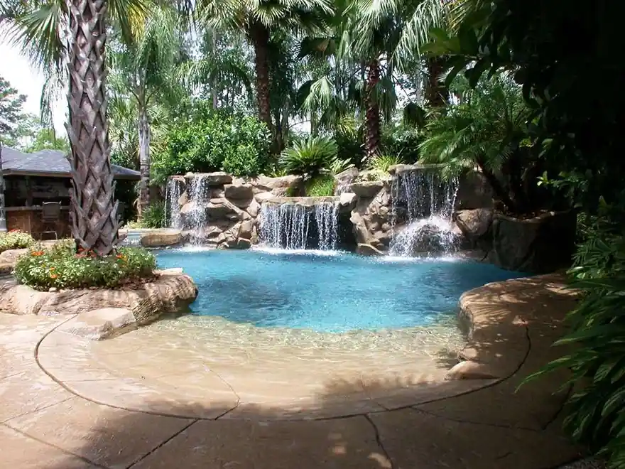 Large pool with grotto waterfalls framed by palms