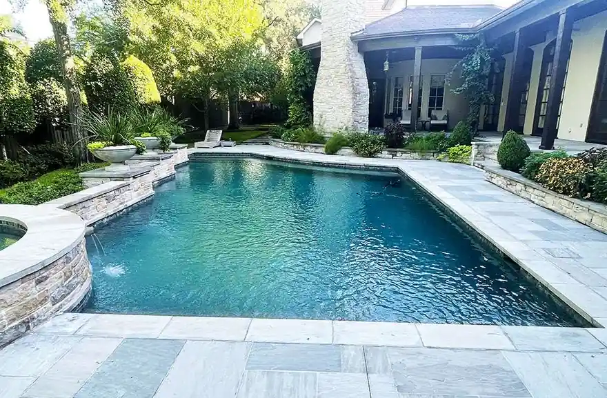 Rectangular pool with a stacked-stone wall and three scupper spouts