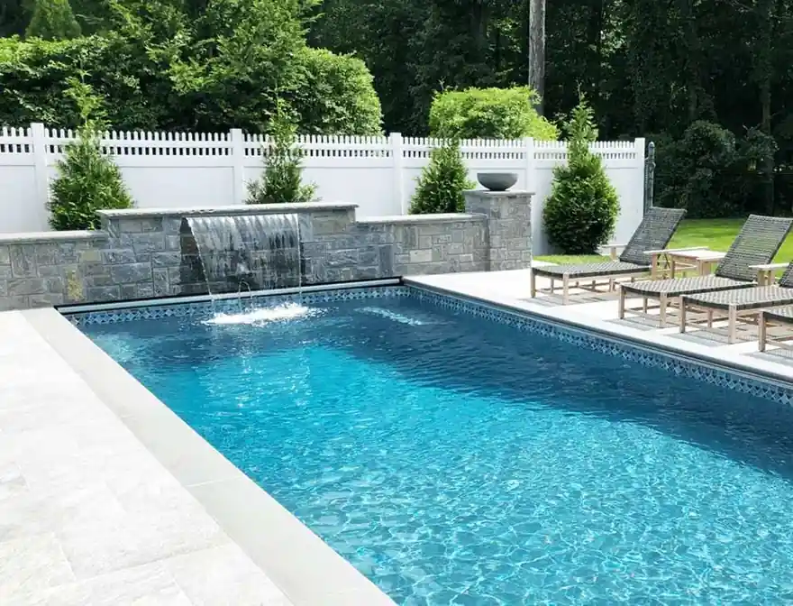 Stacked-stone waterfall wall spilling into a rectangular pool